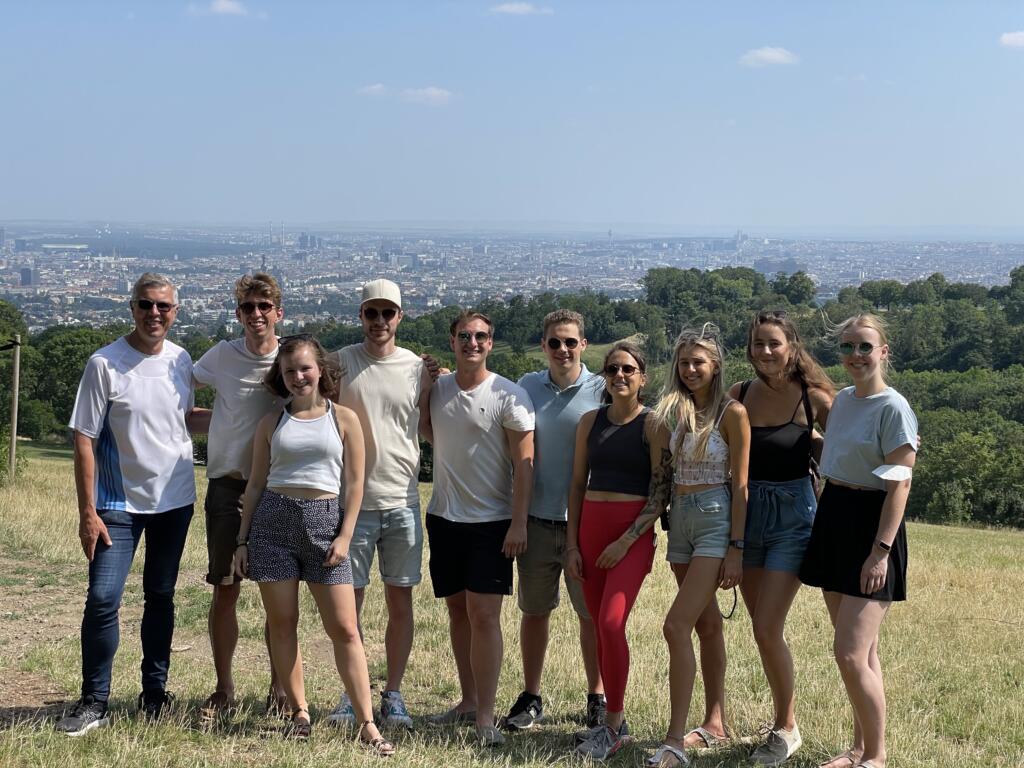 Jobs bei MEDBREAKER: Am Bild sind Mitarbeitende zu sehen. Gemeinsam stehen sie auf einer Wiese, im Hintergrund die Stadt Wien.