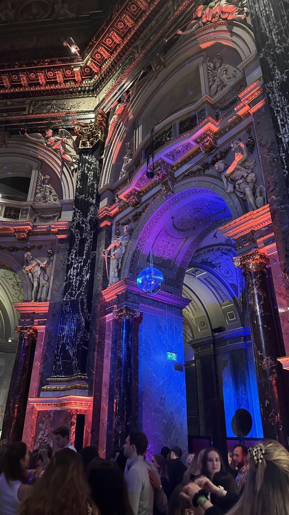 Partyatmosphäre in einer prunkvoll beleuchteten Location (Event Kunstschatz), die das Studentenleben in Wien zeigt.