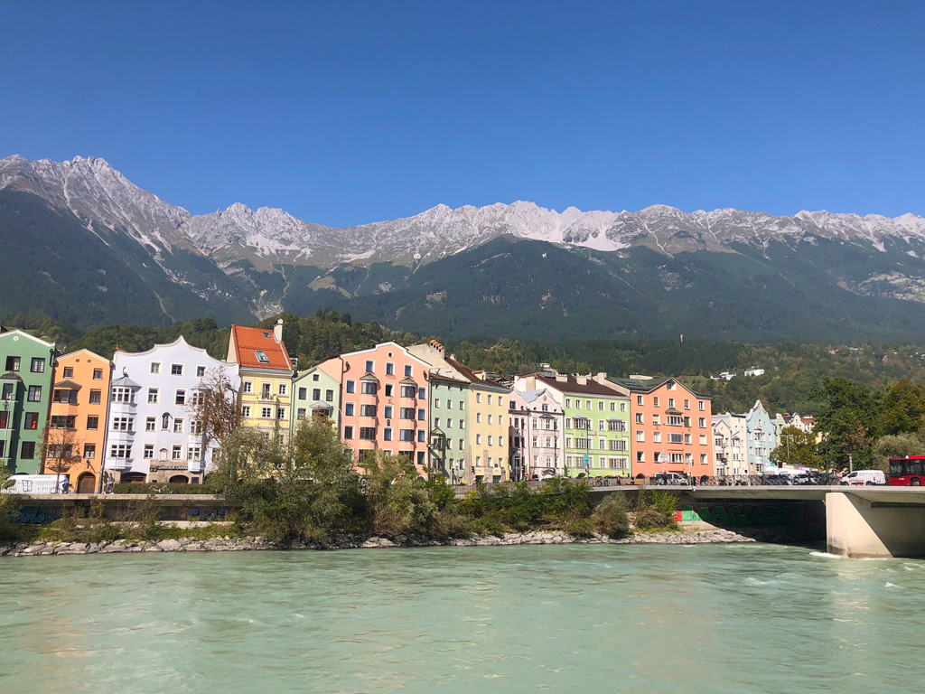 Innsbrucker Altstadt mit farbenfrohen Häusern vor der malerischen Bergkulisse der Alpen.