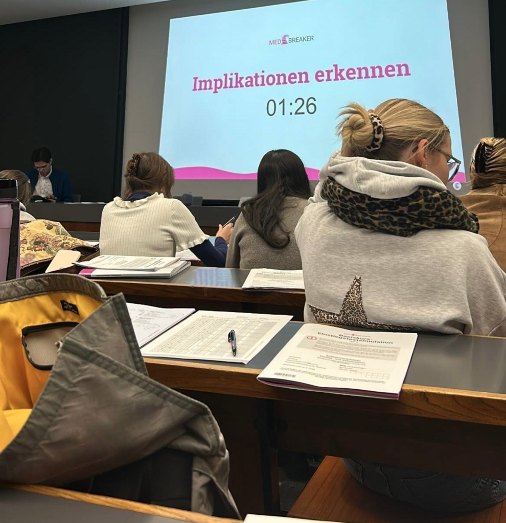 eilnehmer des MEDBREAKER Basiskurses beim Schreiben einer kompletten MedAT-Testsimulation mit dem Fokus auf 'Implikationen erkennen'.